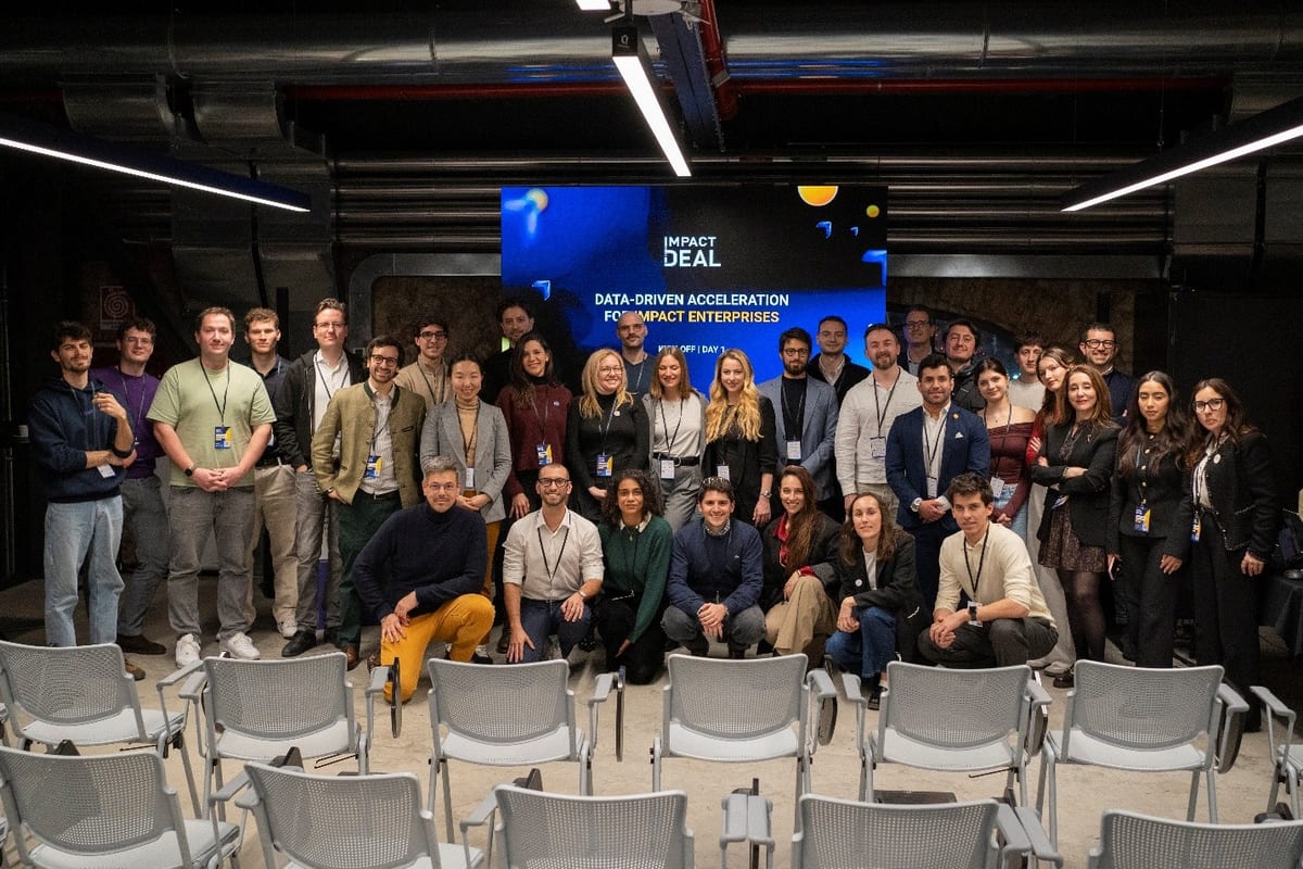 Group photo of the Impact Deal cohort at OGR Torino in front of a Data-Driven Acceleration screen