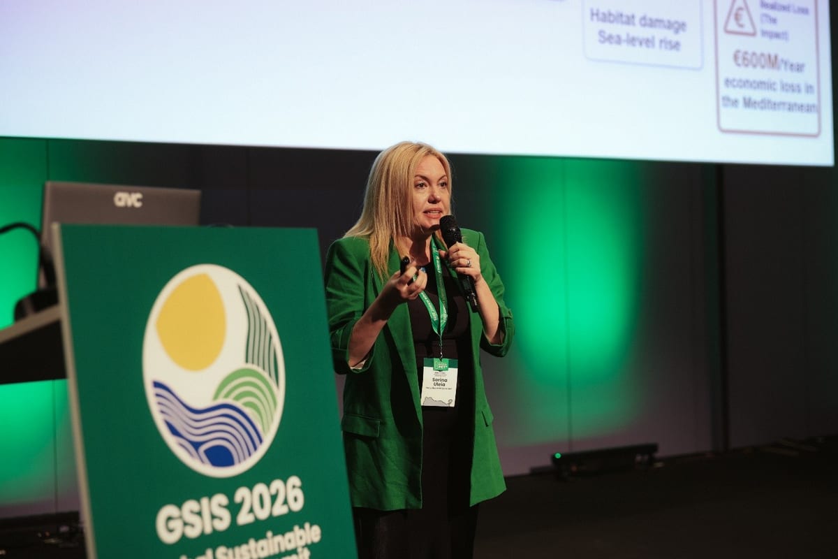 Sorina Uleia in a green blazer speaking on stage beside a GSIS 2026 lectern in Las Palmas